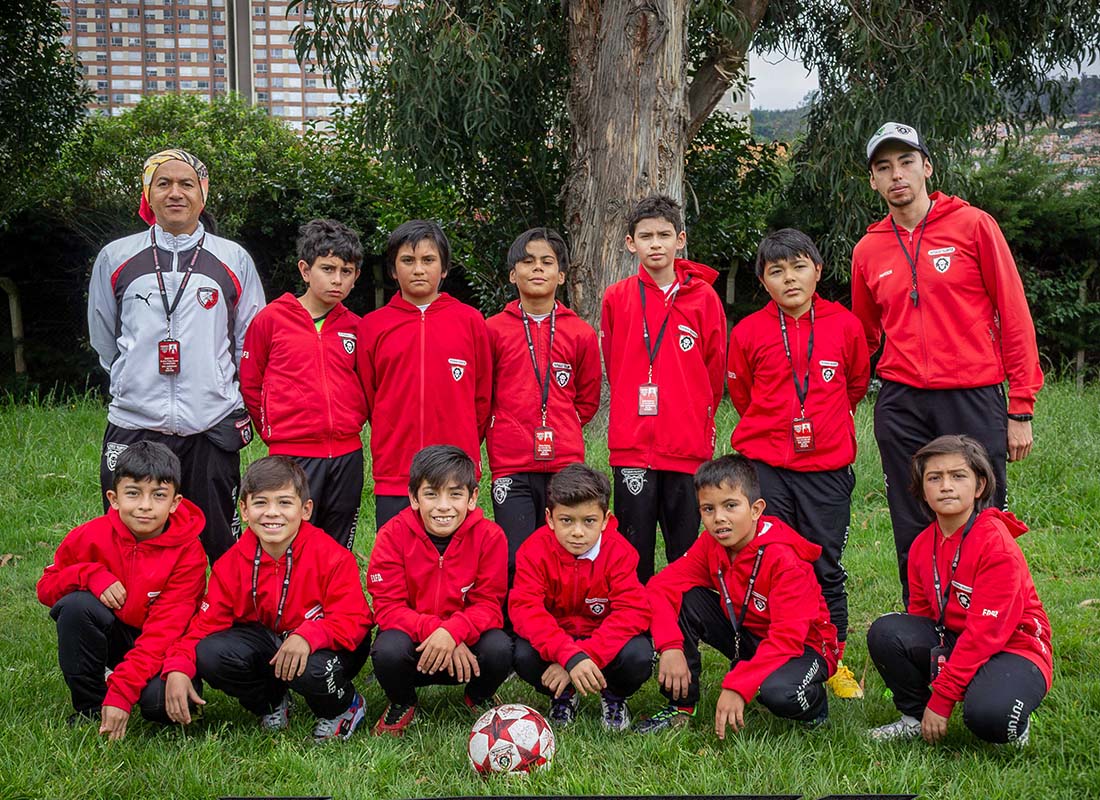 Niños de la categoría sub-11 disputando un balón durante un partido